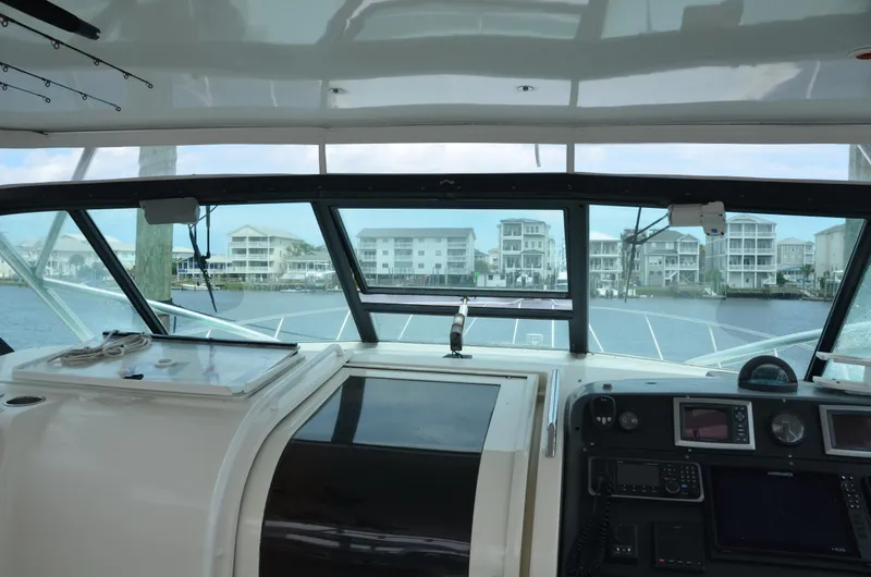 Double Trouble Yacht Photos Pics Interior view of 1992 Tiara Yachts 43 Open, showcasing helm and waterfront scenery.