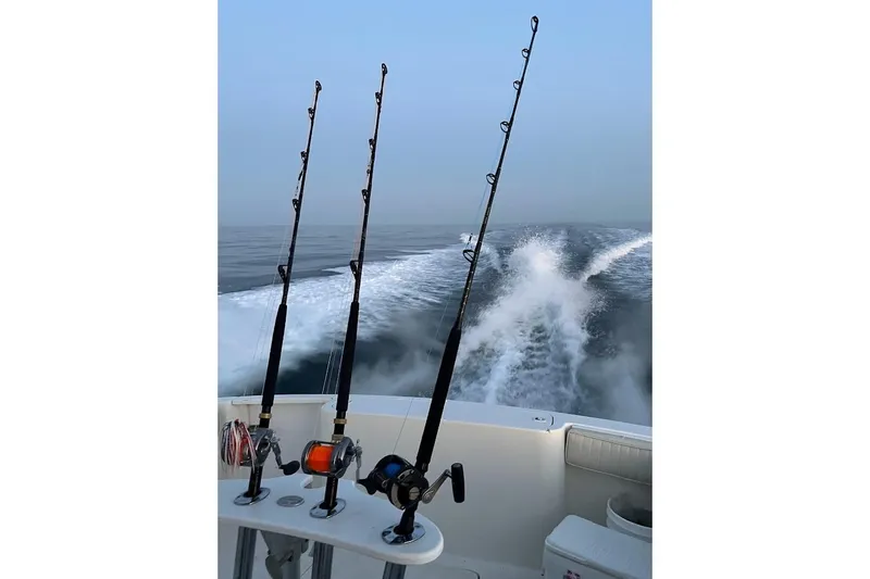 Black Bart Yacht Photos Pics Fishing rods on a 1998 Henriques 28 Express boat, ocean wake in background.