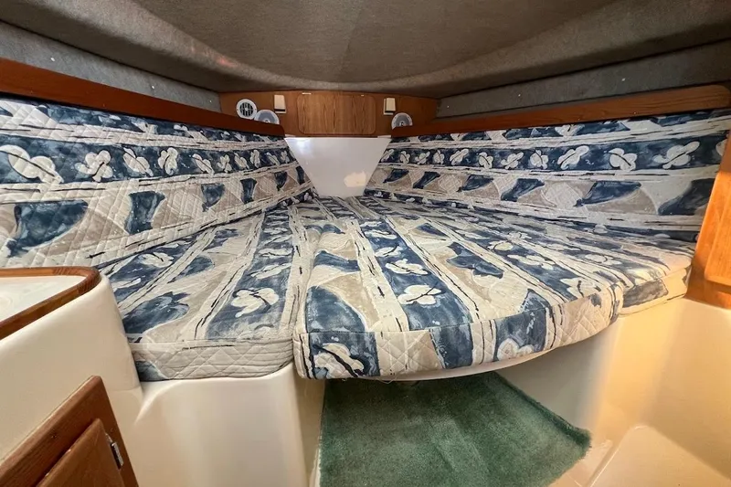 Black Bart Yacht Photos Pics 1998 Henriques 28 Express cabin with floral-patterned bedding and wood accents.