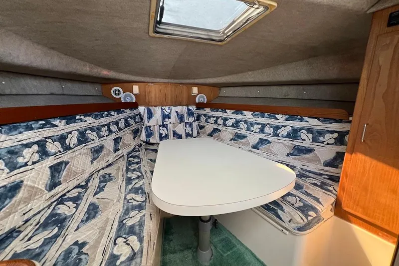 Black Bart Yacht Photos Pics 1998 Henriques 28 Express cabin interior with patterned seating and a central table.