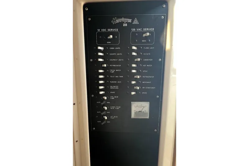 Black Bart Yacht Photos Pics Electrical panel of a 1998 Henriques 28 Express boat, showing 12V and 120V service switches.