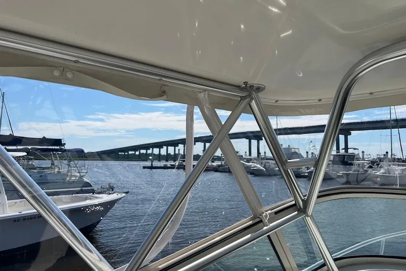 Black Bart Yacht Photos Pics 1998 Henriques 28 Express boat view with marina and bridge in the background.