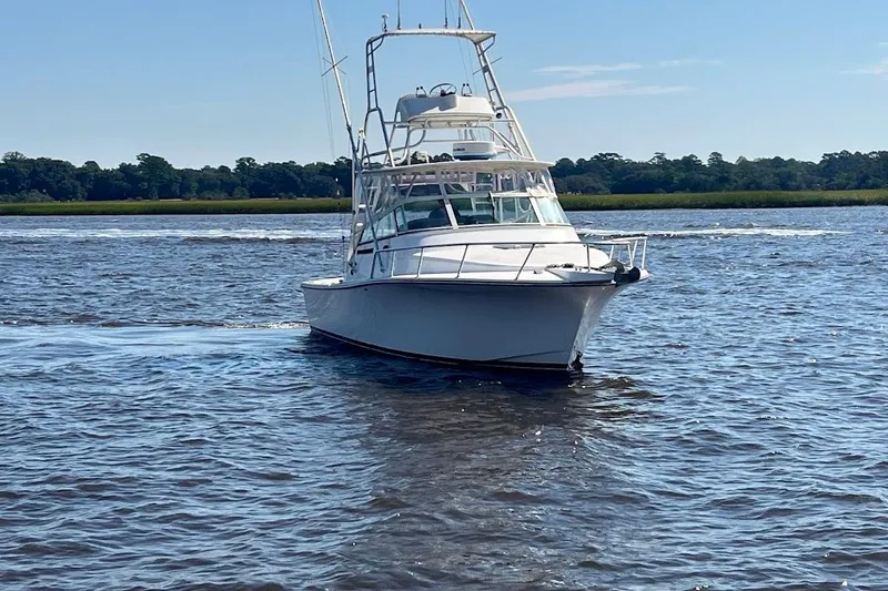 Black Bart Yacht Photos Pics 1998 Henriques 28 Express boat cruising on a sunny day in calm waters.