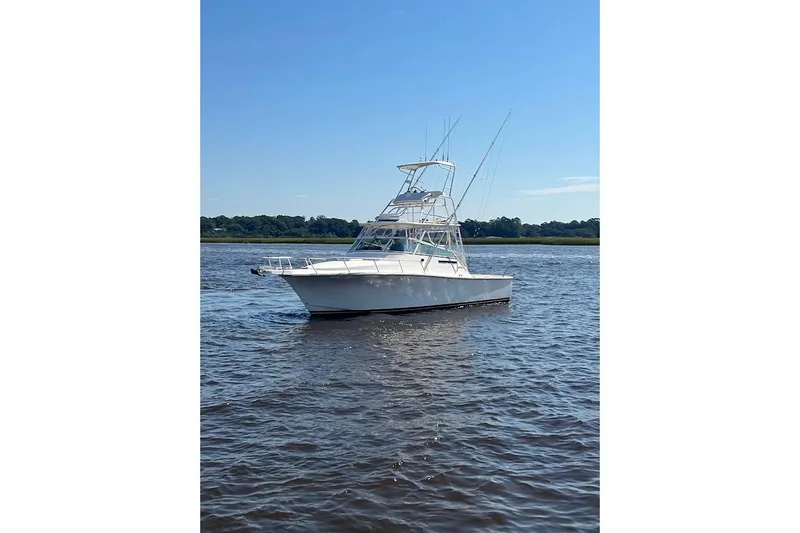 Black Bart Yacht Photos Pics 1998 Henriques 28 Express boat on calm water under clear blue sky.
