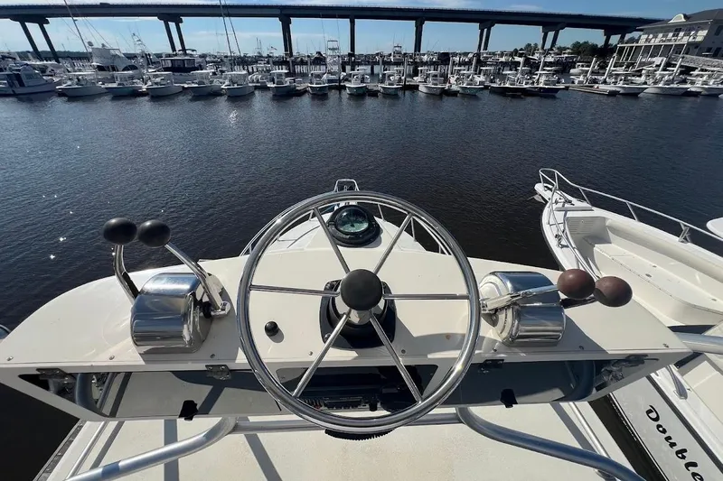 Black Bart Yacht Photos Pics Helm of 1998 Henriques 28 Express boat overlooking marina with bridge in background.