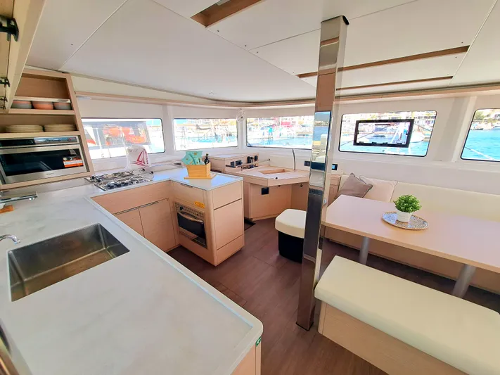  Yacht Photos Pics Modern interior of 2023 Lagoon 46 catamaran with spacious kitchen and seating area.