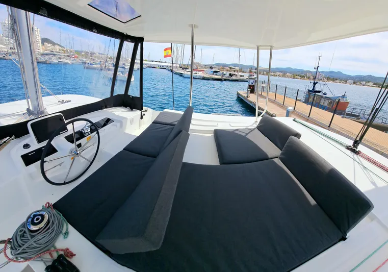  Yacht Photos Pics 2023 Lagoon 46 catamaran with spacious deck, comfortable seating, and scenic marina view.