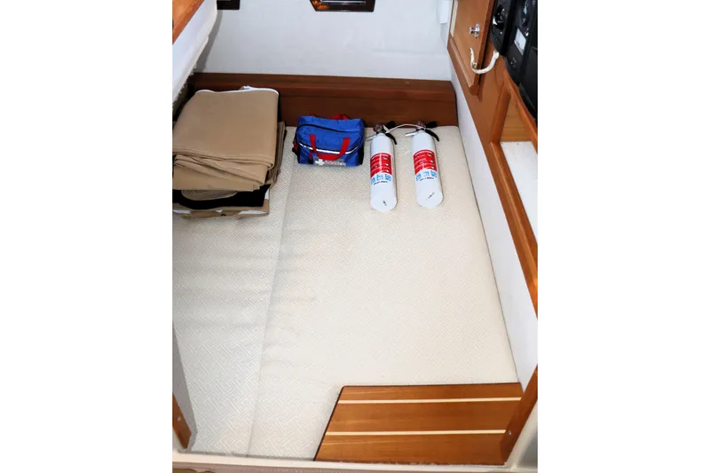 Serafina Yacht Photos Pics 2019 Ranger Tugs R-29 CB interior storage with fire extinguishers and folded items.