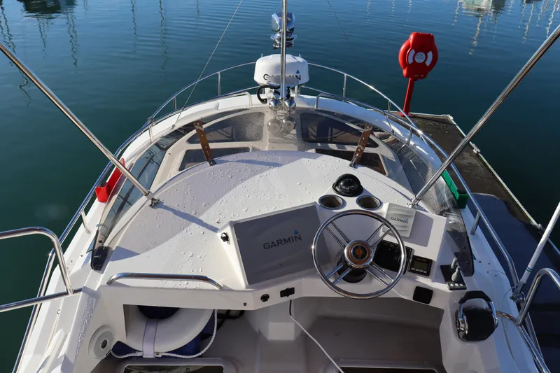 Serafina Yacht Photos Pics 2019 Ranger Tugs R-29 CB boat helm with Garmin navigation system, docked in calm waters.