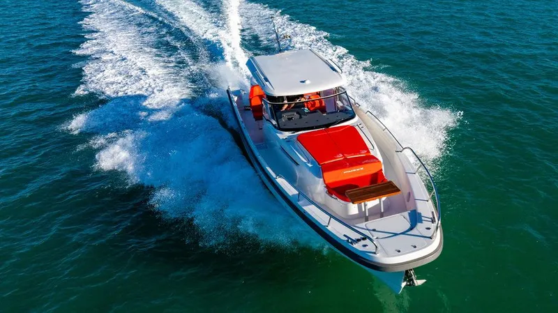 Volare Yacht Photos Pics 2023 Nimbus T11 boat cruising on open water, showcasing sleek design and vibrant red accents.
