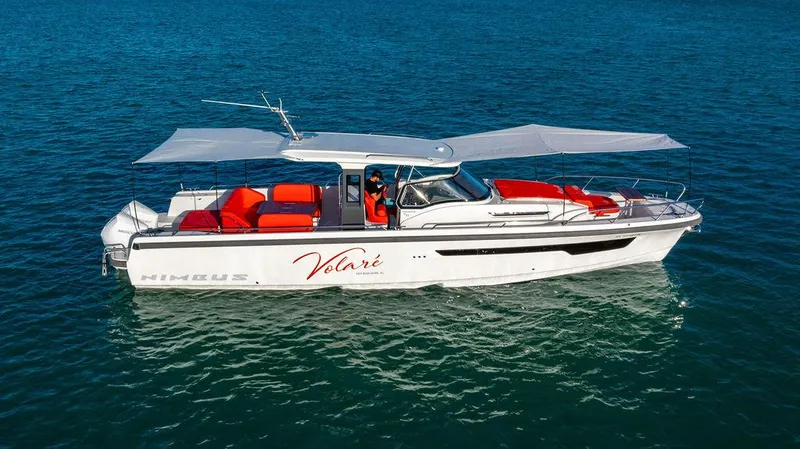Volare Yacht Photos Pics 2023 Nimbus T11 boat with red seating, cruising on clear blue water.