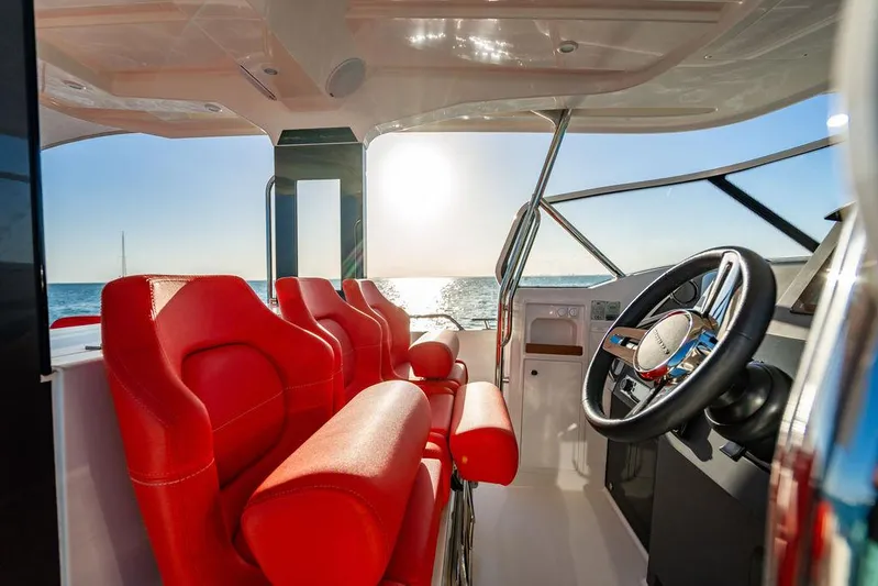 Volare Yacht Photos Pics Luxurious 2023 Nimbus T11 boat interior with red seats and ocean view.