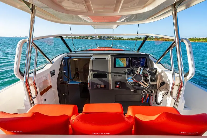 Volare Yacht Photos Pics 2023 Nimbus T11 boat cockpit with red seats, steering wheel, and navigation screens.