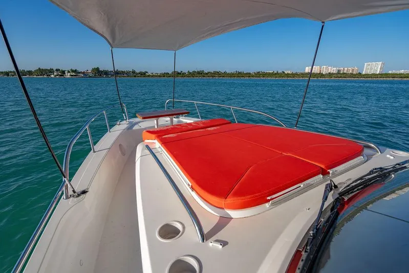 Volare Yacht Photos Pics 2023 Nimbus T11 boat with red sunbed on deck, sailing in clear blue waters.