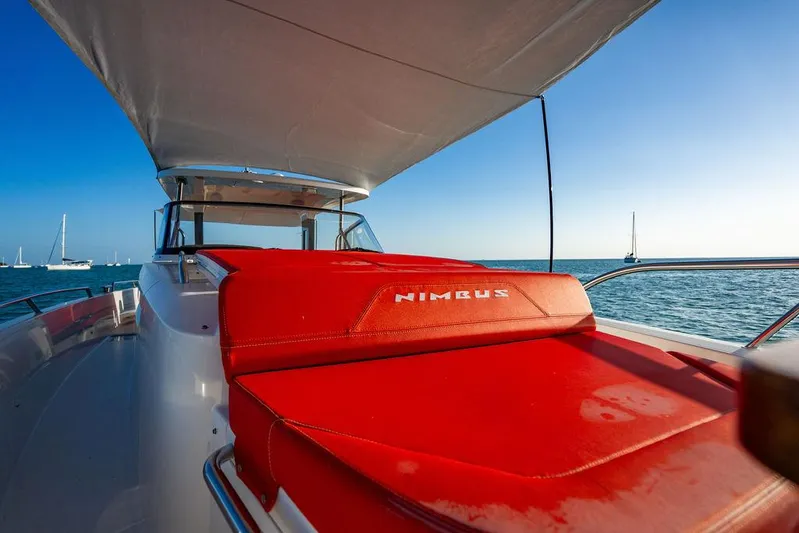 Volare Yacht Photos Pics 2023 Nimbus T11 yacht with red seating, sailing on a clear blue sea.