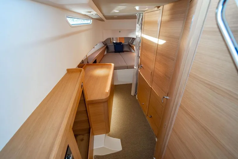 Volare Yacht Photos Pics 2023 Nimbus T11 cabin interior with wooden furnishings and cozy bed.