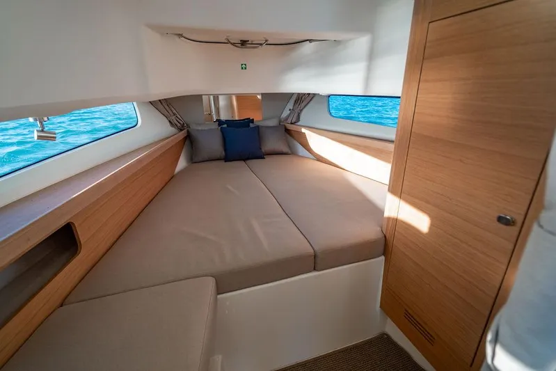 Volare Yacht Photos Pics 2023 Nimbus T11 cabin interior with cozy bed and wooden accents.