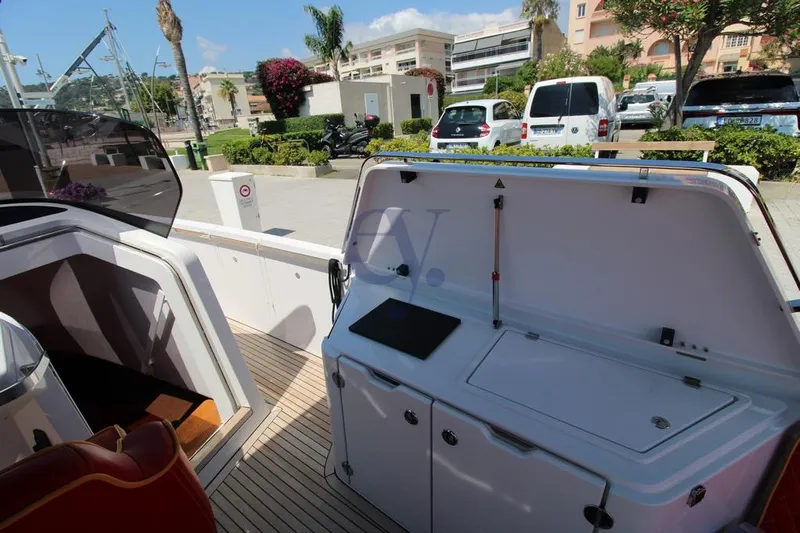 S Yacht Photos Pics 2024 Frauscher 1414 Demon Air yacht deck with open storage compartment, docked in a marina.