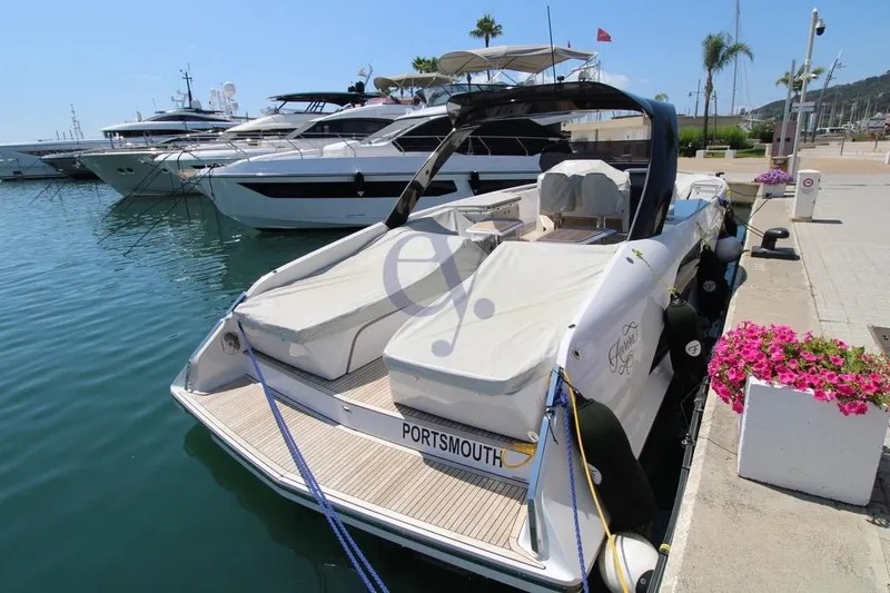 S Yacht Photos Pics 2024 Frauscher 1414 Demon Air yacht docked in a marina, surrounded by other luxury boats.