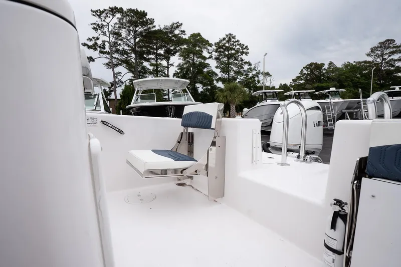  Yacht Photos Pics 2025 Twin Vee 260 GFX2 CC boat interior with seating and ladder, surrounded by trees.