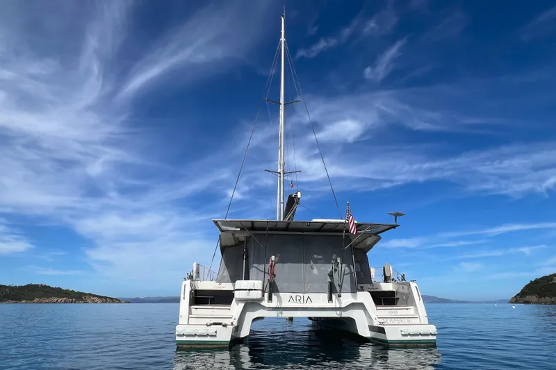 Aria Yacht Photos Pics 2023 Fountaine Pajot Elba 45 Catamaran on calm sea under clear blue sky.