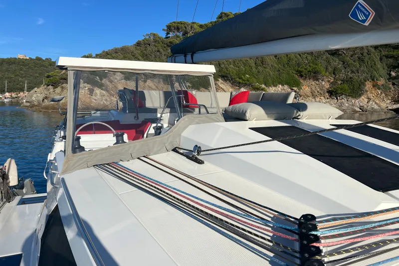 Aria Yacht Photos Pics 2023 Fountaine Pajot Elba 45 Catamaran docked in scenic coastal waters.