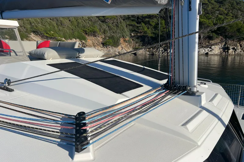 Aria Yacht Photos Pics 2023 Fountaine Pajot Elba 45 Catamaran deck with ropes and scenic coastal backdrop.