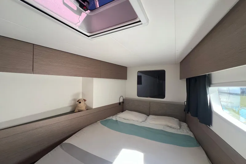 Aria Yacht Photos Pics 2023 Fountaine Pajot Elba 45 Catamaran cabin interior with bed and skylight.