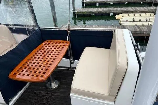 Shearwater Yacht Photos Pics Grand Banks 36 Classic 2000 yacht with cushioned seating and wooden table on deck.