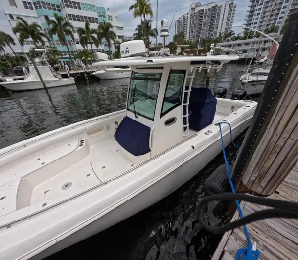  Yacht Photos Pics 2013 Boston Whaler 320 Outrage docked at marina, surrounded by palm trees and buildings.