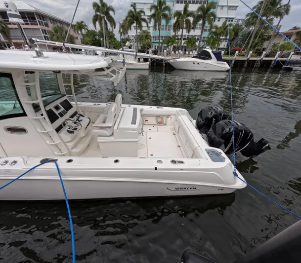  Yacht Photos Pics 2013 Boston Whaler 320 Outrage boat docked in marina with palm trees.