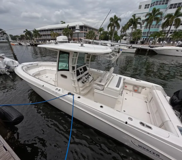  Yacht Photos Pics 2013 Boston Whaler 320 Outrage boat docked in marina, surrounded by palm trees.
