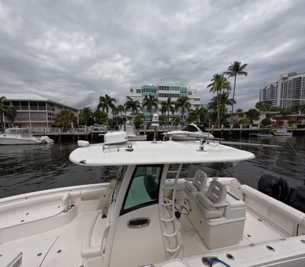  Yacht Photos Pics 2013 Boston Whaler 320 Outrage boat docked in a marina with cloudy skies.