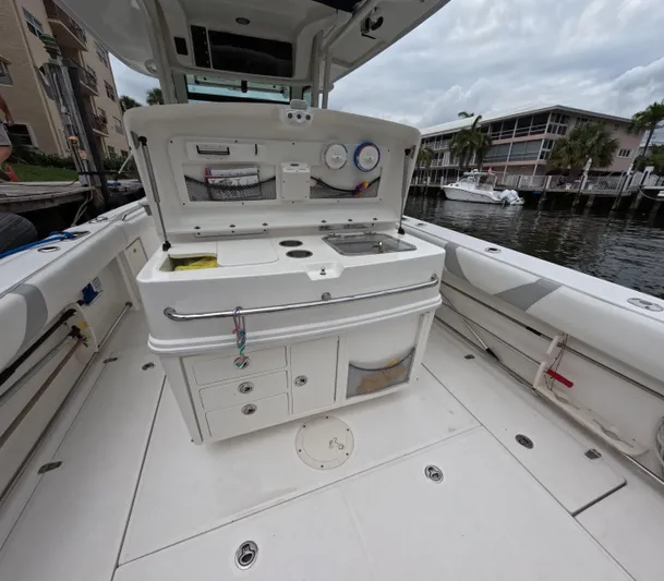  Yacht Photos Pics 2013 Boston Whaler 320 Outrage boat interior with open storage and fishing equipment.