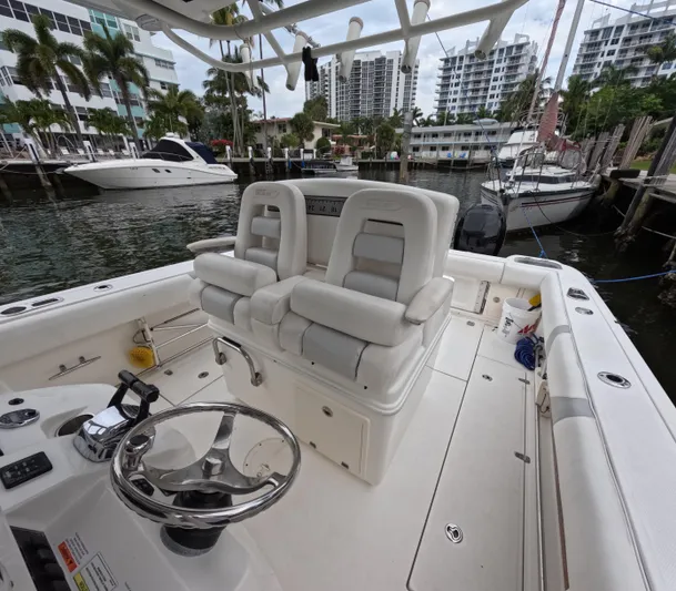  Yacht Photos Pics 2013 Boston Whaler 320 Outrage boat interior with helm and seating, docked near yachts.
