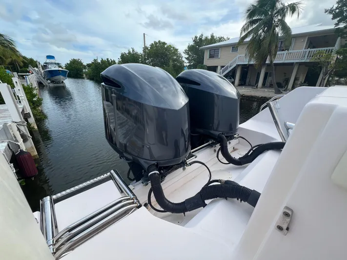  Yacht Photos Pics 2011 Grady-White Canyon 306 boat with dual outboard motors docked by a canal.