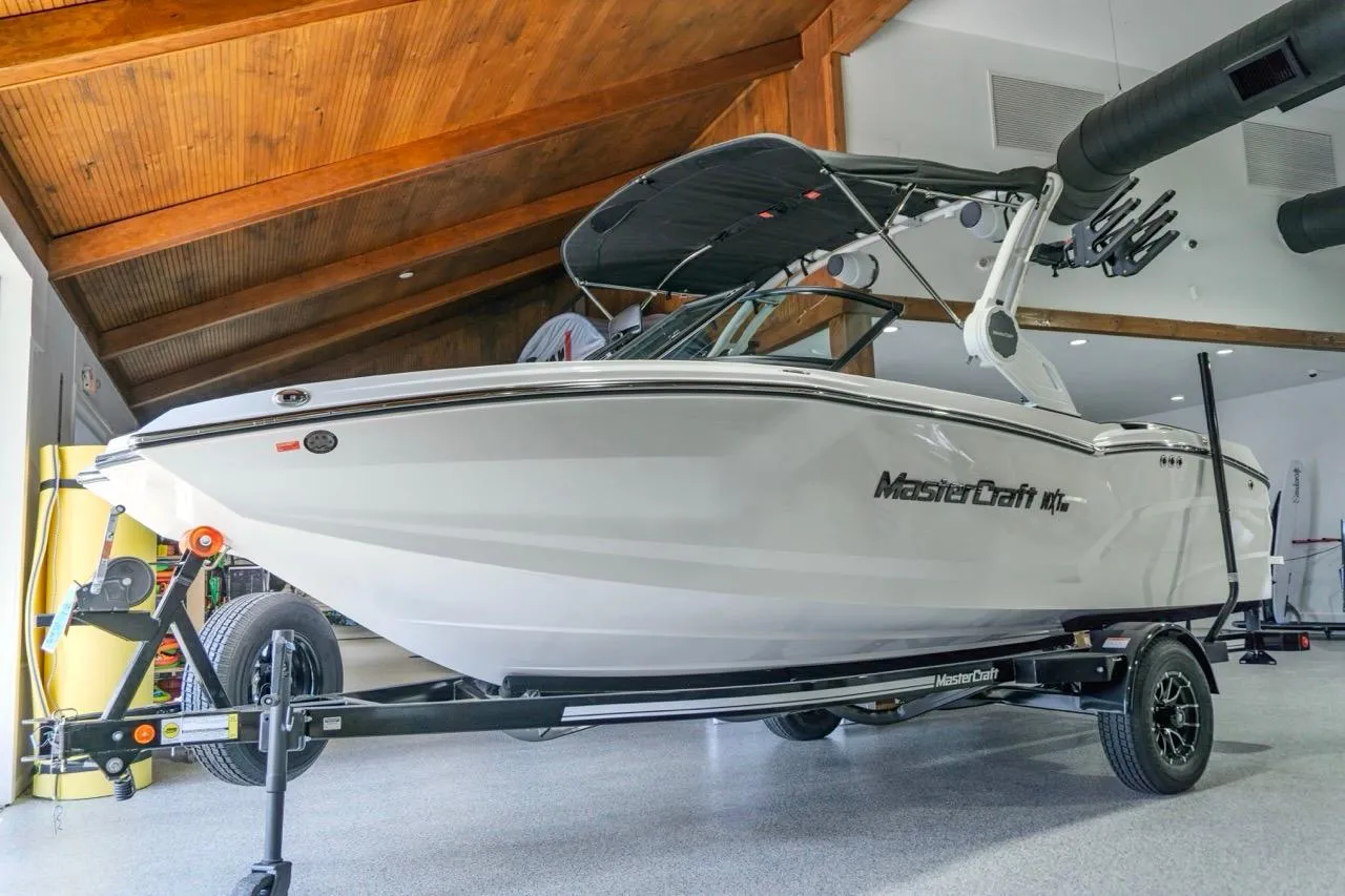 2026 MasterCraft NXT20 boat on trailer in a modern garage setting.