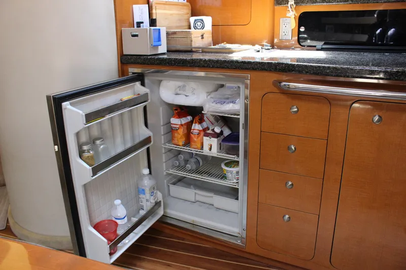 Happy Ours Yacht Photos Pics 2008 Chaparral 350 Signature yacht kitchen with open fridge and wooden cabinetry.