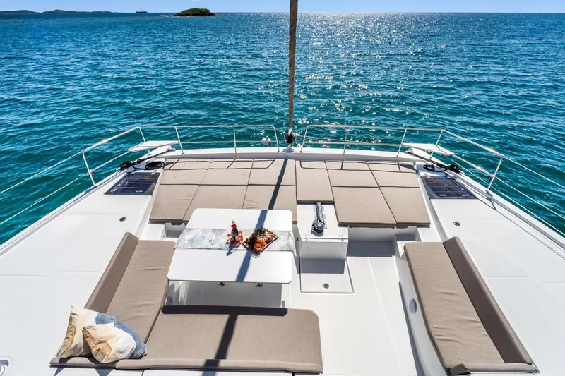 C Sisters Yacht Photos Pics 2023 Bali 5.4 Catamaran deck with seating, table, and ocean view.
