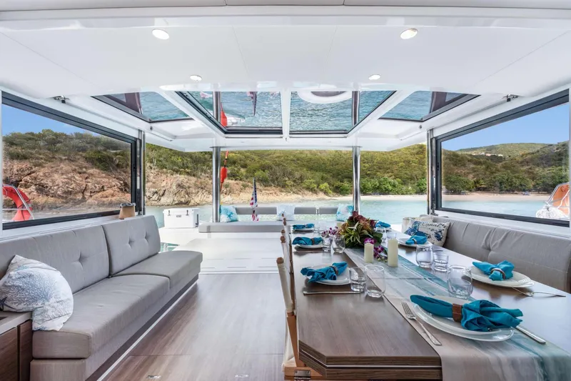 C Sisters Yacht Photos Pics Luxurious interior of 2023 Bali 5.4 Catamaran with elegant dining setup and scenic ocean view.