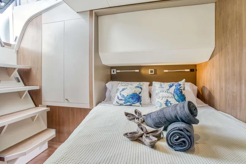 C Sisters Yacht Photos Pics Luxurious cabin interior of 2023 Bali 5.4 Catamaran with cozy bedding and elegant decor.