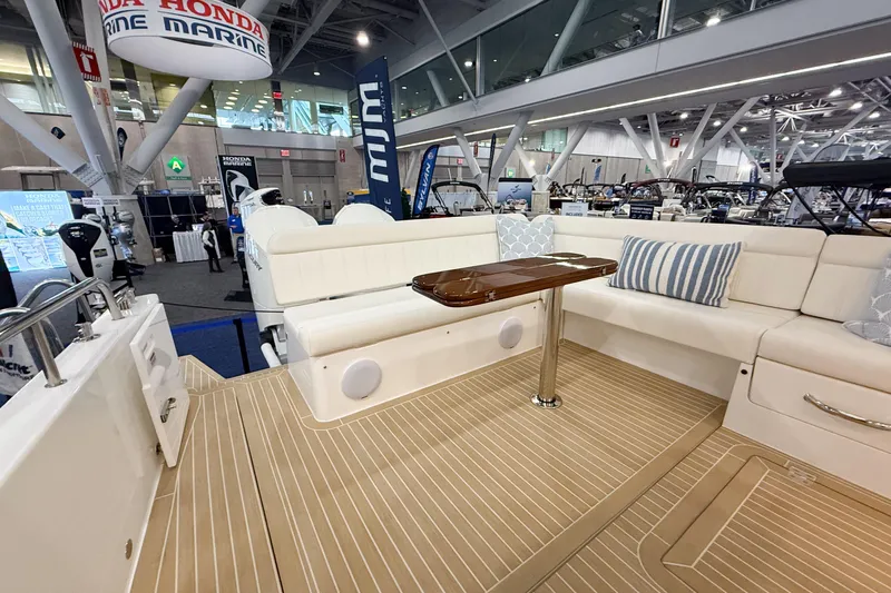 In Stock Yacht Photos Pics Luxurious 2026 MJM 47X yacht interior with elegant seating and wooden table at a boat show.