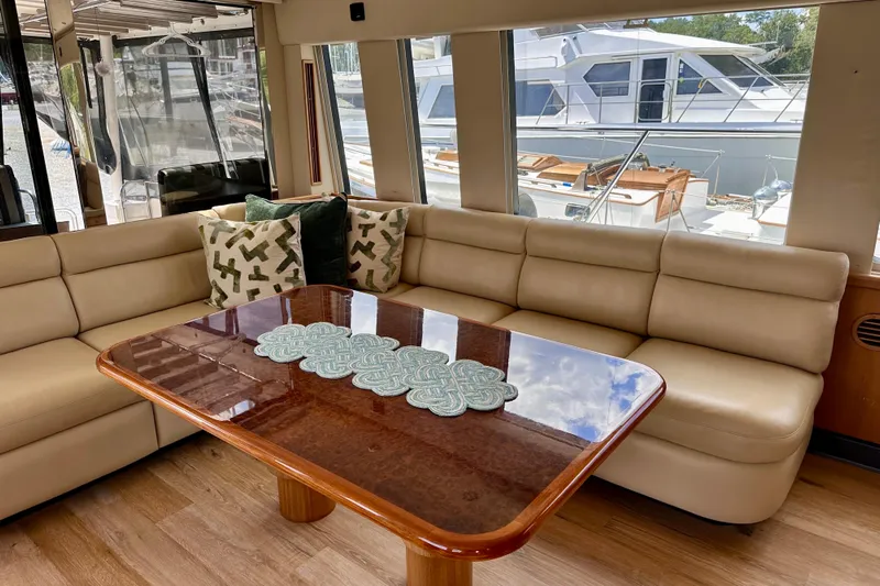Chasing Sunsets Yacht Photos Pics Luxurious interior of 2000 Pacific Mariner 65 Motoryacht with elegant seating and table.