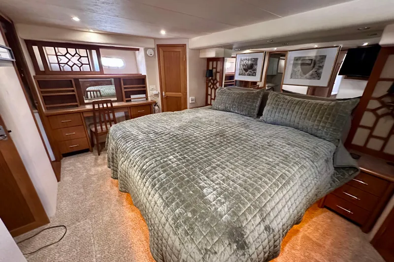 Chasing Sunsets Yacht Photos Pics Luxurious bedroom in 2000 Pacific Mariner 65 Motoryacht with plush bedding and elegant wood furnishings.