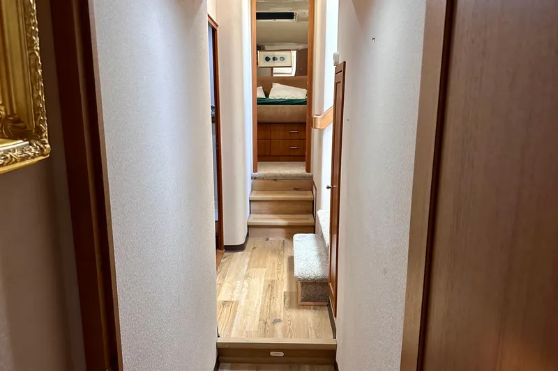Chasing Sunsets Yacht Photos Pics Interior hallway of 2000 Pacific Mariner 65 Motoryacht with wooden flooring and steps.