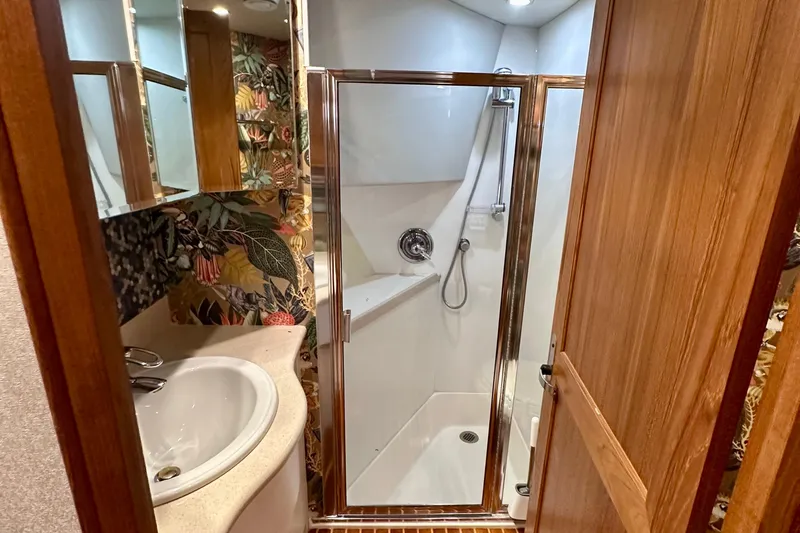 Chasing Sunsets Yacht Photos Pics Luxurious bathroom in 2000 Pacific Mariner 65 Motoryacht with shower and floral wallpaper.