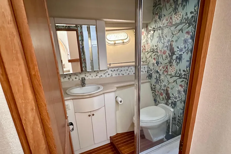 Chasing Sunsets Yacht Photos Pics Bathroom interior of 2000 Pacific Mariner 65 Motoryacht with floral wallpaper and modern fixtures.