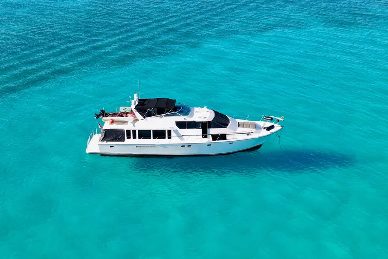 Chasing Sunsets Yacht Photos Pics 2000 Pacific Mariner 65 Motoryacht cruising on clear turquoise waters.