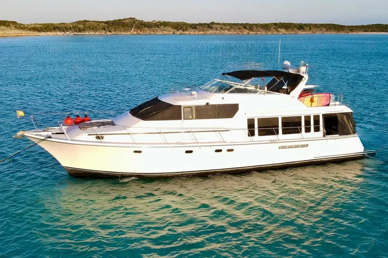 Chasing Sunsets Yacht Photos Pics 2000 Pacific Mariner 65 Motoryacht on tranquil blue waters, side view.