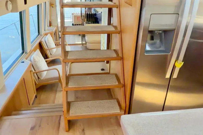 Chasing Sunsets Yacht Photos Pics Interior of 2000 Pacific Mariner 65 Motoryacht with wooden stairs and modern kitchen.